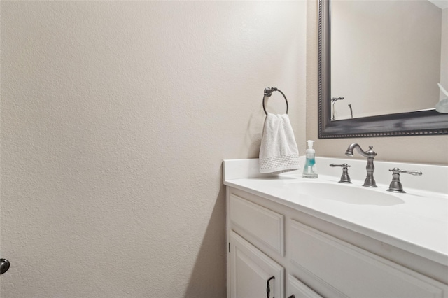 bathroom with vanity and a textured wall