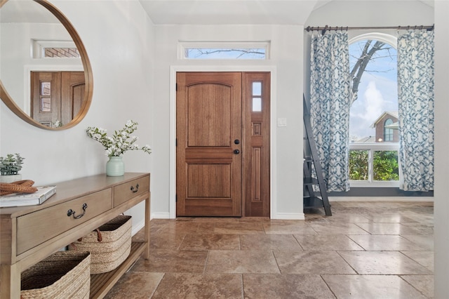 entrance foyer with lofted ceiling and baseboards