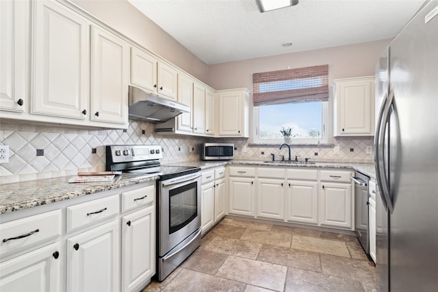 kitchen with a sink, white cabinets, under cabinet range hood, and stainless steel appliances