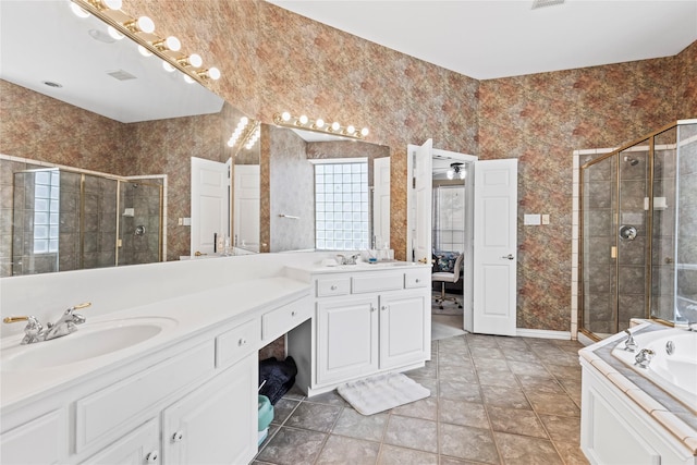 bathroom with a shower stall, wallpapered walls, a garden tub, double vanity, and a sink