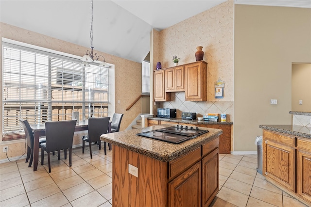 kitchen with backsplash, lofted ceiling, an inviting chandelier, light tile patterned flooring, and black electric cooktop