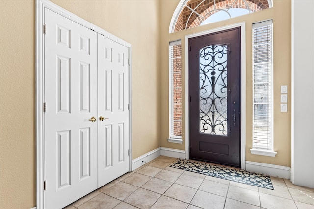 entrance foyer featuring light tile patterned flooring and baseboards