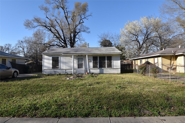 bungalow-style house featuring a front lawn and fence