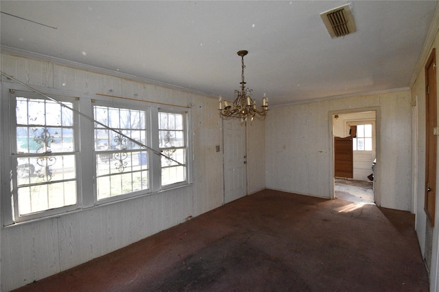 unfurnished dining area with an inviting chandelier, crown molding, visible vents, and carpet floors