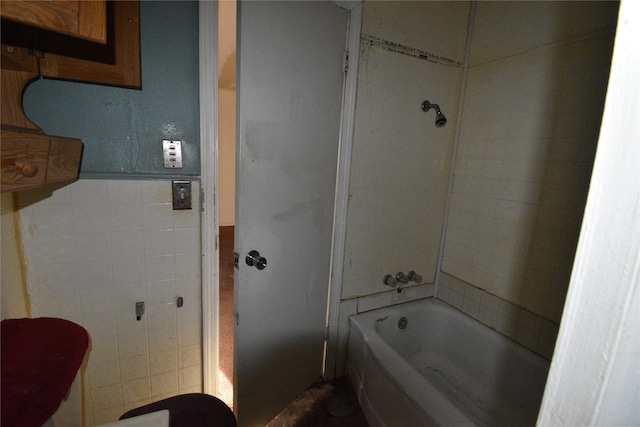 full bath featuring tile walls and shower / bath combination