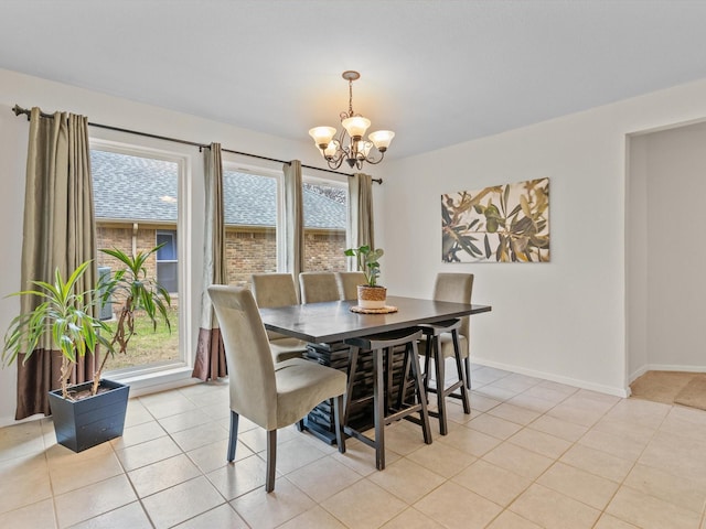 dining area with an inviting chandelier, light tile patterned floors, baseboards, and a wealth of natural light