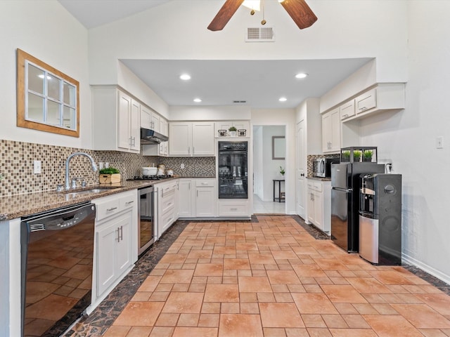 kitchen featuring tasteful backsplash, wine cooler, stone countertops, black appliances, and a sink