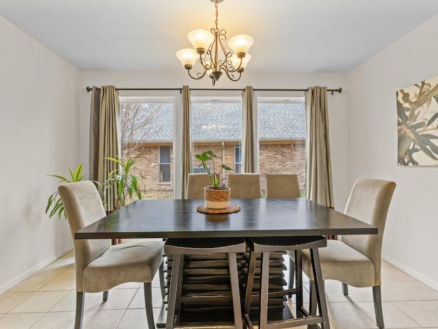 dining area with light tile patterned floors, baseboards, and a chandelier