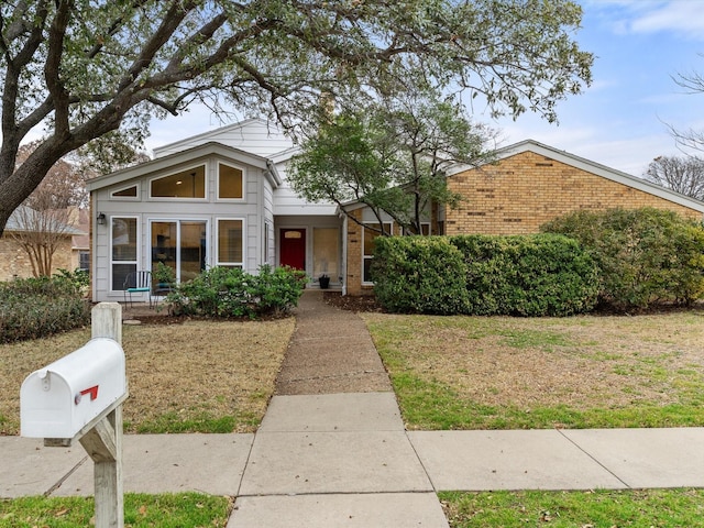 view of front of home featuring brick siding and a front yard