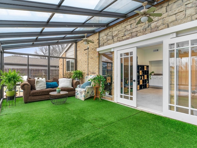 unfurnished sunroom featuring ceiling fan