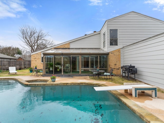 exterior space featuring fence, a fenced in pool, an in ground hot tub, a sunroom, and a patio area