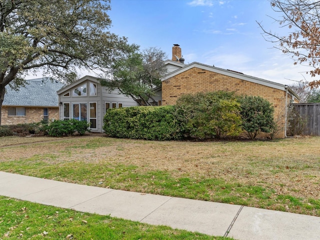 3320 Canyon Valley Trl, Plano, TX 75023 - view of front of property with brick siding, a front lawn, a chimney, and fence