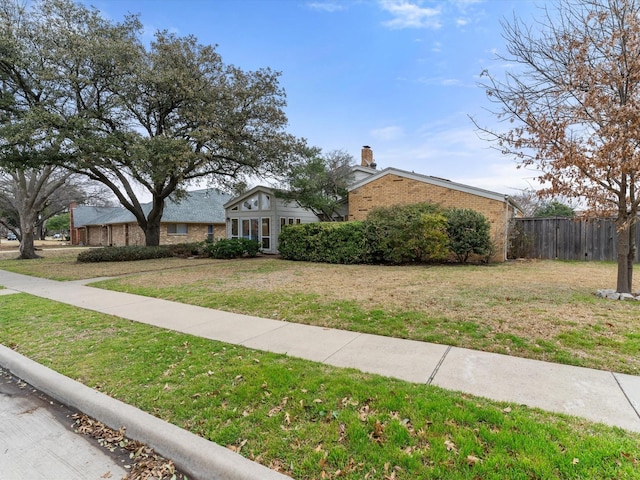 3320 Canyon Valley Trl, Plano, TX 75023 - view of front of property with brick siding, a chimney, a front yard, and fence