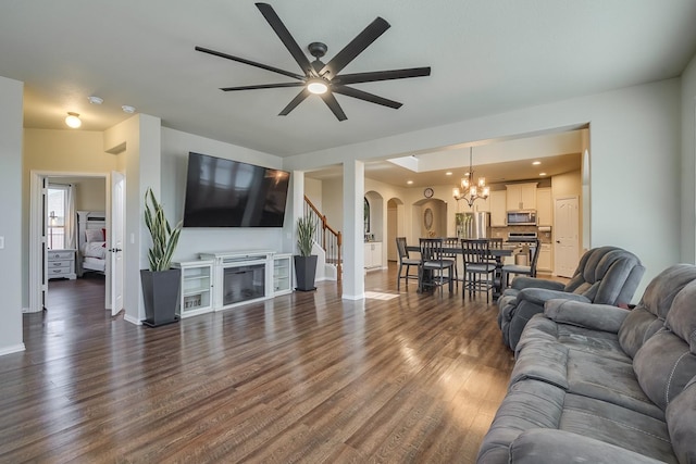 living room with baseboards, dark wood finished floors, stairway, arched walkways, and a glass covered fireplace