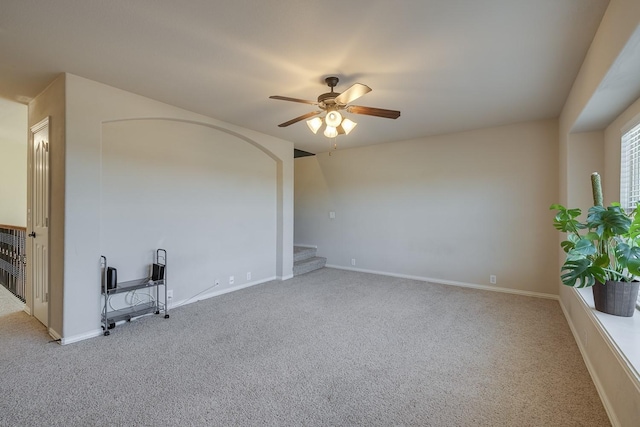 unfurnished room with stairway, carpet flooring, baseboards, and a ceiling fan