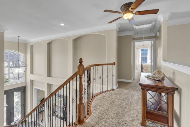 hall with an upstairs landing, ornamental molding, carpet flooring, baseboards, and attic access