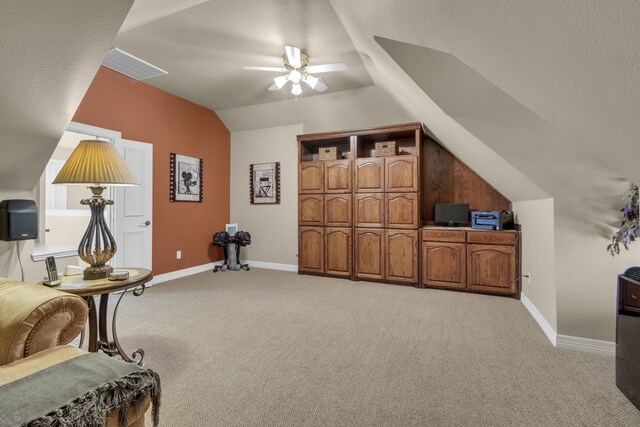 bedroom featuring baseboards, light carpet, a textured ceiling, and lofted ceiling