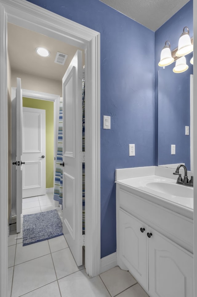 bathroom with tile patterned flooring, visible vents, vanity, and baseboards