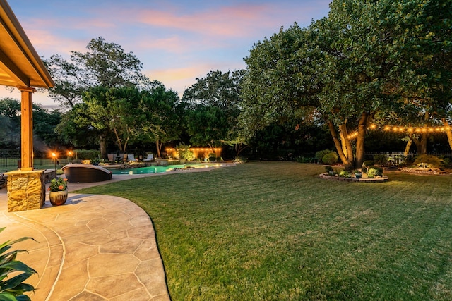 yard at dusk featuring a patio area, an outdoor pool, and fence