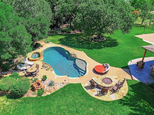 view of swimming pool featuring a fire pit, a lawn, and a patio area