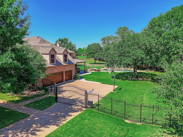 view of community with concrete driveway, a gate, a lawn, and fence