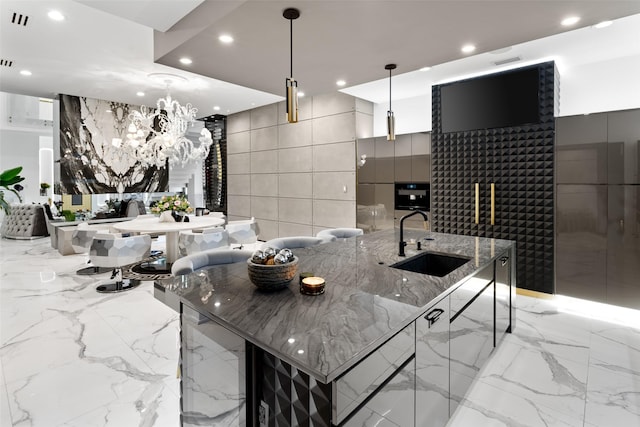 kitchen with marble finish floor, modern cabinets, a sink, recessed lighting, and stone wall