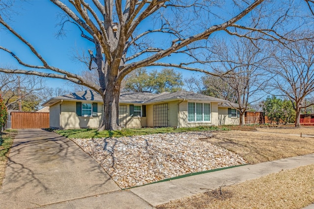 ranch-style house featuring brick siding and fence