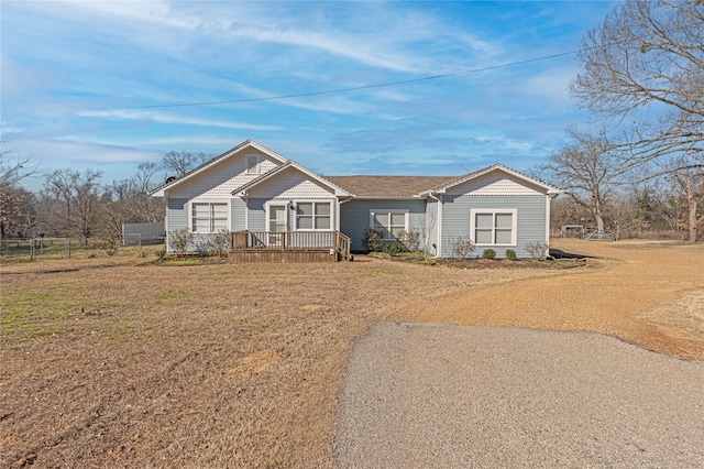 view of front facade featuring a deck, a front yard, and fence