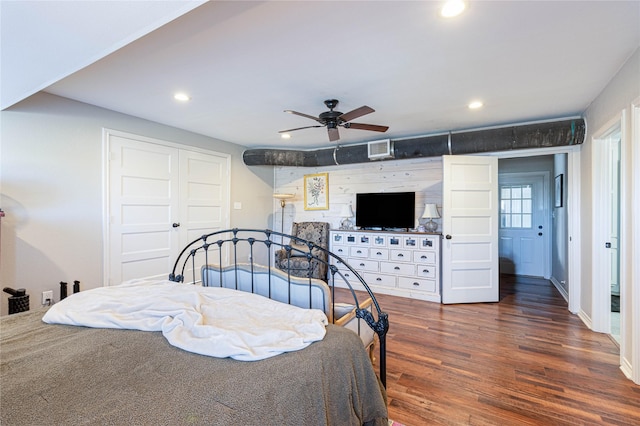 bedroom with dark wood finished floors, visible vents, recessed lighting, and a closet