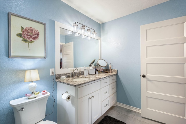 bathroom with tile patterned floors, toilet, vanity, and baseboards