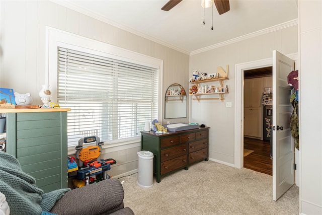 carpeted bedroom with ornamental molding and a ceiling fan