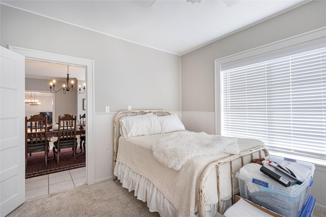 carpeted bedroom with multiple windows and ceiling fan with notable chandelier