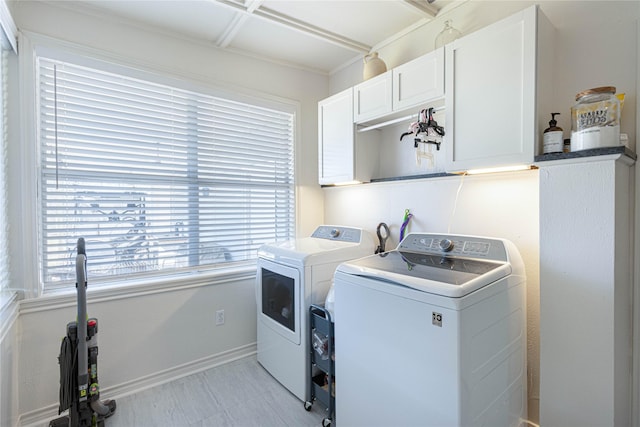 laundry room with washing machine and dryer, cabinet space, and baseboards