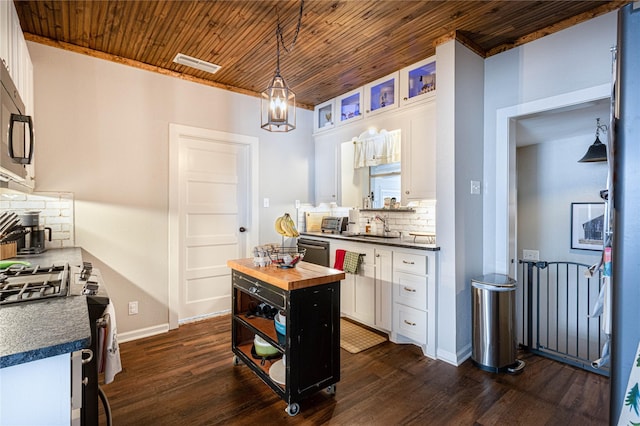 kitchen with visible vents, a sink, wood counters, white cabinets, and dishwashing machine