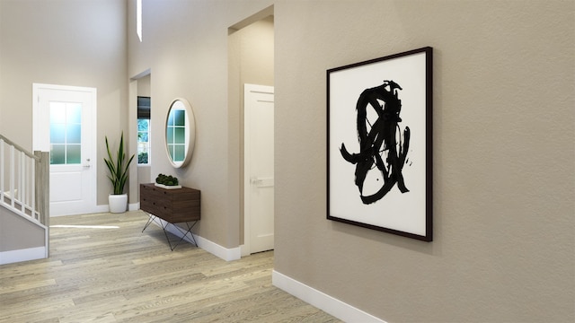 entrance foyer featuring light wood-type flooring, baseboards, and stairs