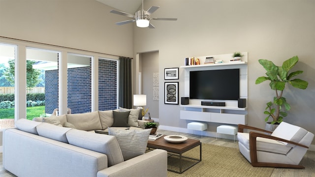 living area with a towering ceiling, baseboards, wood finished floors, and a ceiling fan