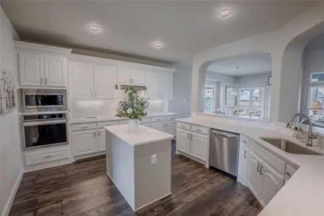 kitchen with light countertops, white cabinets, appliances with stainless steel finishes, and a sink