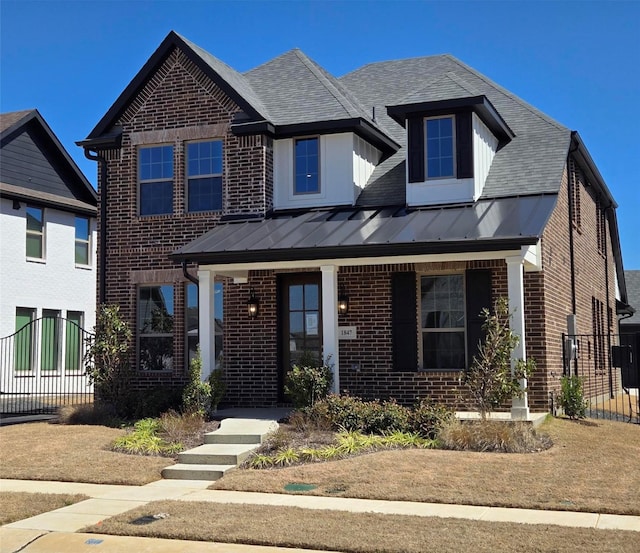 view of front of house featuring brick siding, fence, covered porch, a standing seam roof, and a gate