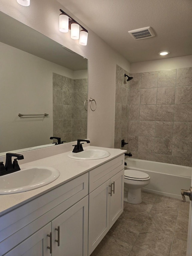 full bathroom with a sink, visible vents, toilet, and washtub / shower combination