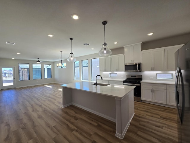 kitchen with visible vents, dark wood finished floors, a sink, stainless steel appliances, and white cabinets