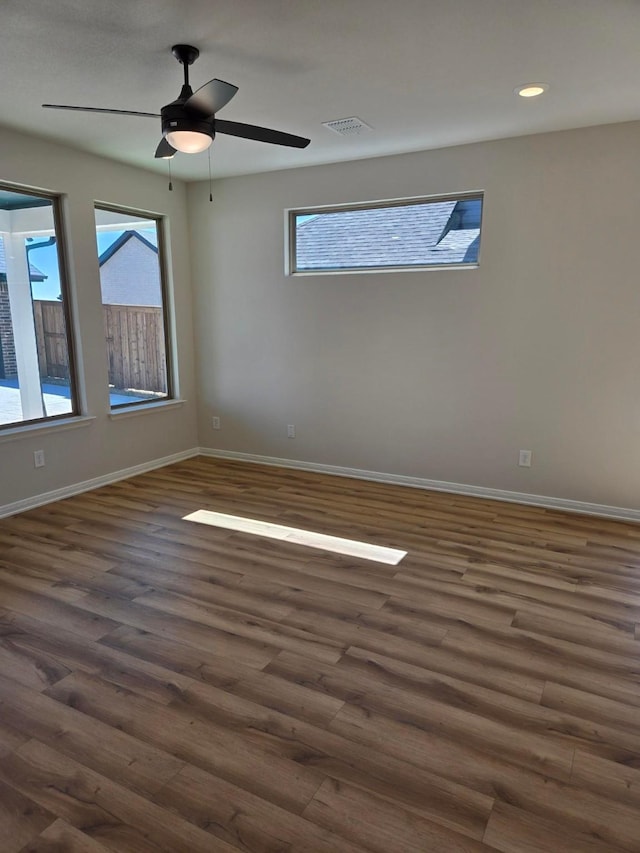 empty room featuring visible vents, a ceiling fan, dark wood finished floors, recessed lighting, and baseboards