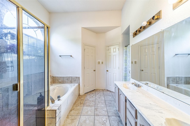 full bathroom featuring tile patterned flooring, a garden tub, double vanity, a stall shower, and a sink