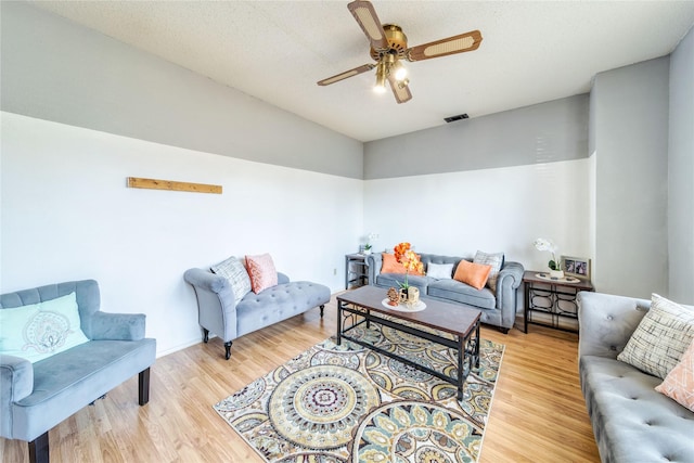 living room featuring a ceiling fan, wood finished floors, and visible vents