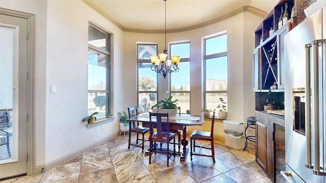 dining room with crown molding, a notable chandelier, and baseboards