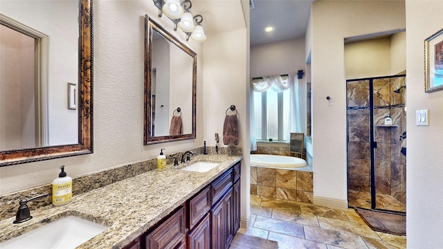 bathroom featuring stone tile flooring, a tile shower, a garden tub, and a sink