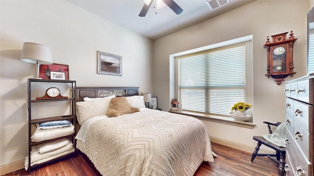 bedroom featuring ceiling fan, wood finished floors, visible vents, and baseboards