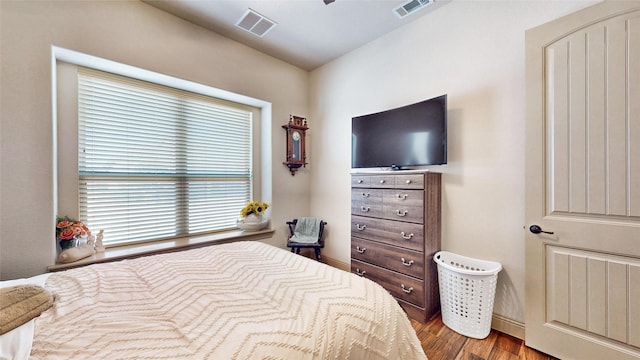 bedroom with visible vents and wood finished floors