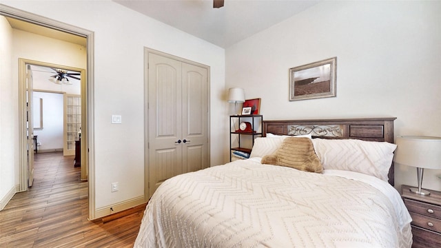 bedroom featuring ceiling fan, wood finished floors, a closet, and baseboards