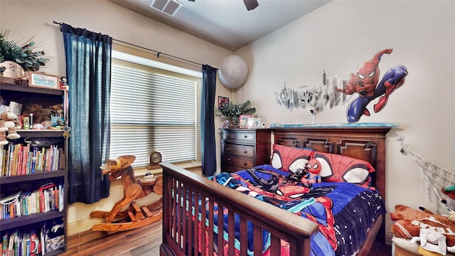 bedroom featuring wood finished floors, visible vents, and ceiling fan