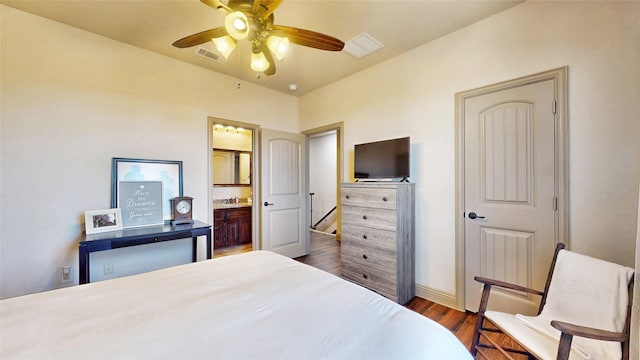 bedroom with ensuite bath, wood finished floors, visible vents, and ceiling fan